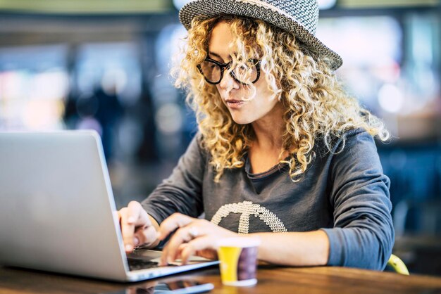 Foto junge frau benutzt laptop im café