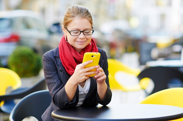 Junge Frau benutzt Smartphone im Café