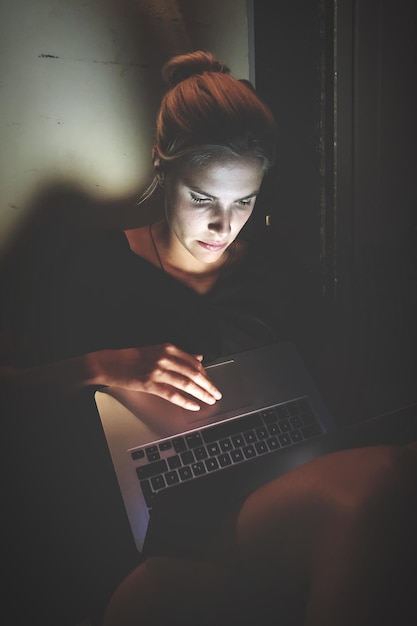 Junge Frau benutzt zu Hause einen Laptop