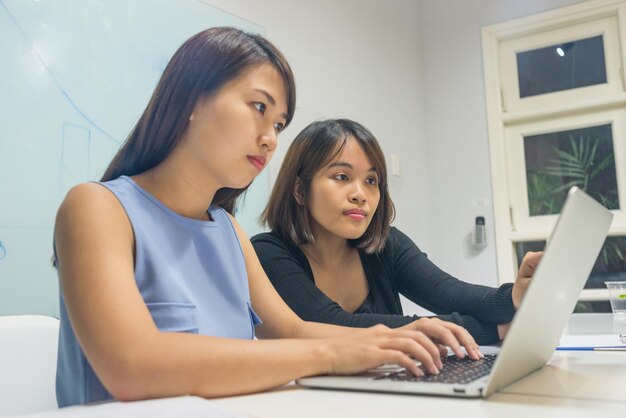 Junge Frau benutzt zu Hause einen Laptop