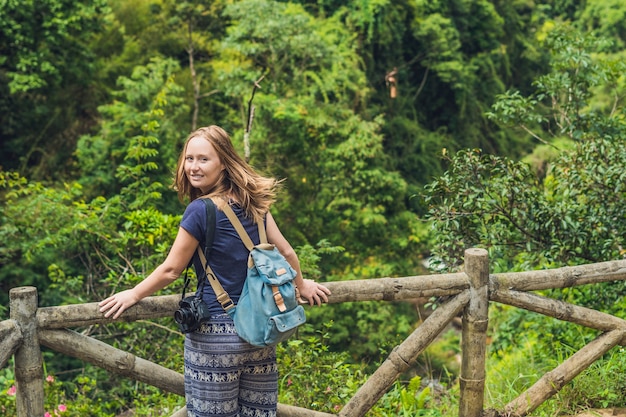 Junge Frau bewundert die Natur von Vietnam durch ländlichen Zaun