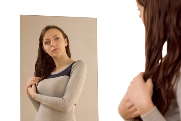 Foto junge frau bewundert sich im spiegel