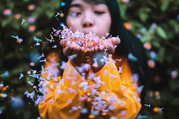 Foto junge frau bläst blumen