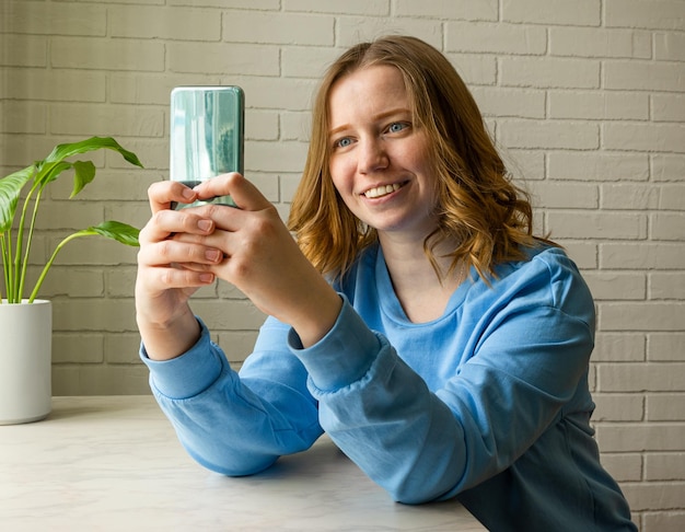 Junge Frau chattet online oder macht ein Selfie