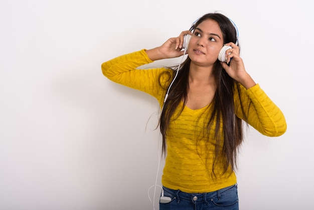 Junge Frau denkt beim Aufschauen und Musikhören