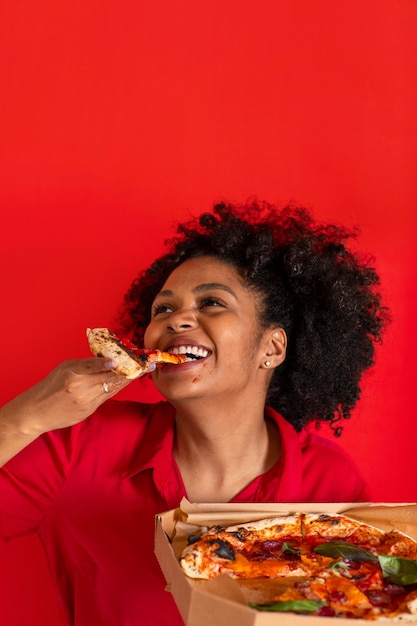 Junge Frau der Vorderansicht, die köstliche Pizza isst