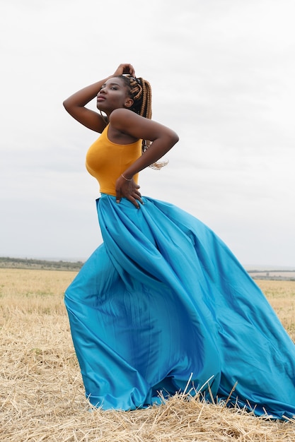 Junge Frau des Afroamerikaners, die Spaß im Freien bei Sonnenuntergang hat. lachendes Mädchen auf dem Feld. schöne junge Afroamerikanerin mit Zöpfen