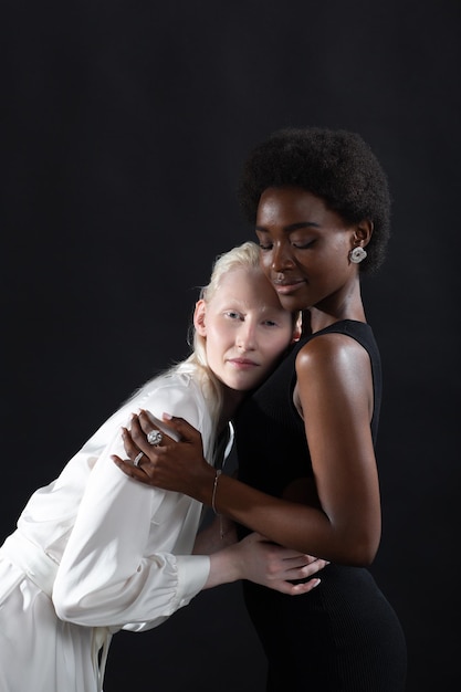 Junge Frau des Kaukasiers und des Afroamerikaners lokalisiert auf schwarzem Hintergrund