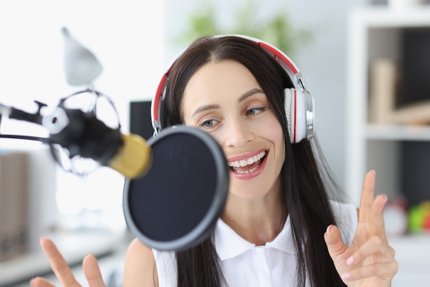 Junge Frau des Porträts, die Podcast im Studio aufzeichnet.