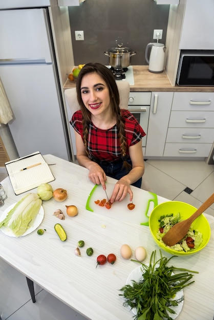 Junge Frau, die Abendessen in einer Küche zubereitet. gesunder Lebensstil.