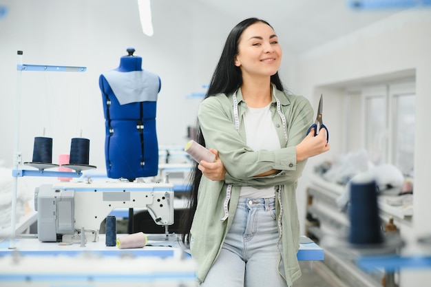 Junge Frau, die als Näherin in einer Bekleidungsfabrik arbeitet