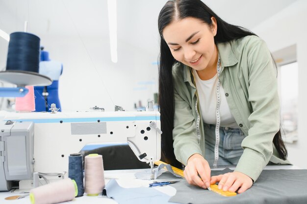 Junge Frau, die als Näherin in einer Bekleidungsfabrik arbeitet