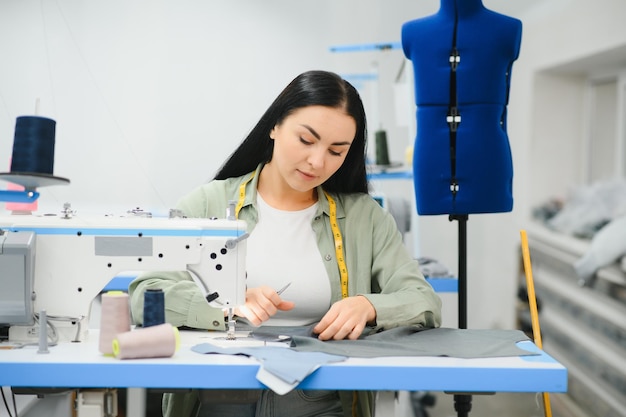 Junge Frau, die als Näherin in einer Bekleidungsfabrik arbeitet