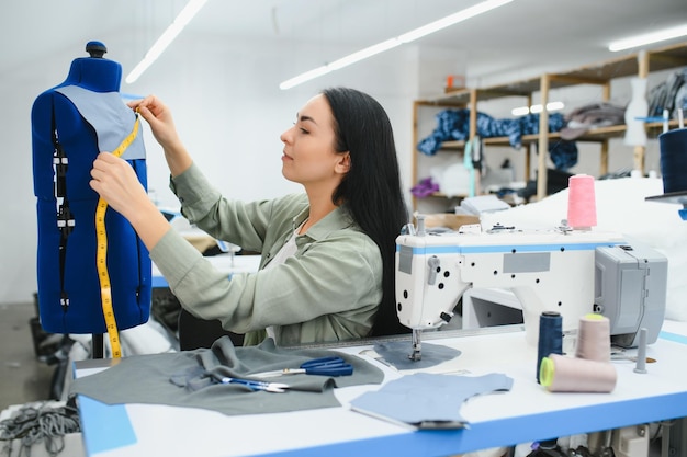 Junge Frau, die als Näherin in einer Bekleidungsfabrik arbeitet