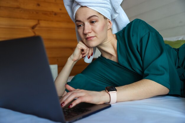 Junge Frau, die am Computer nach einer Dusche arbeitet