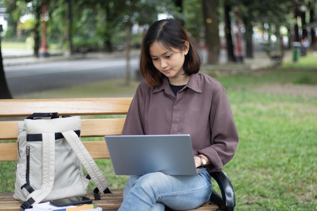 Junge Frau, die am Park studiert