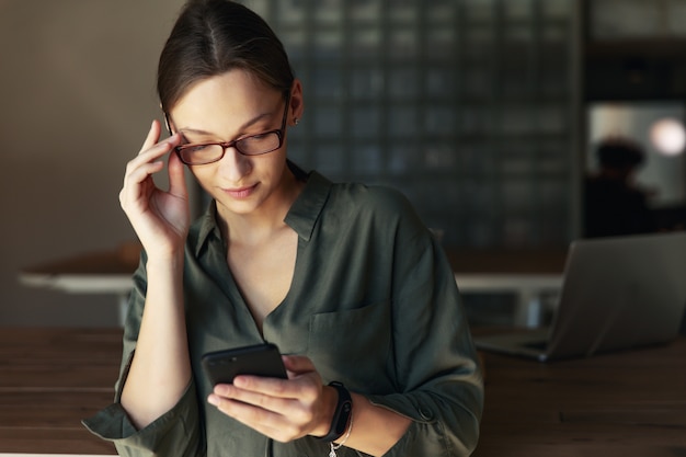 Junge Frau, die am Telefon in der Bar arbeitet