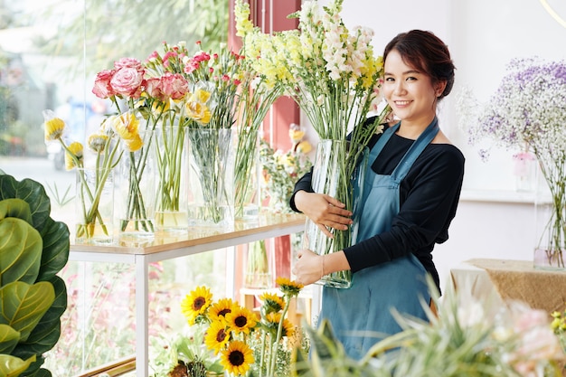 Junge Frau, die an Blumenboutique arbeitet