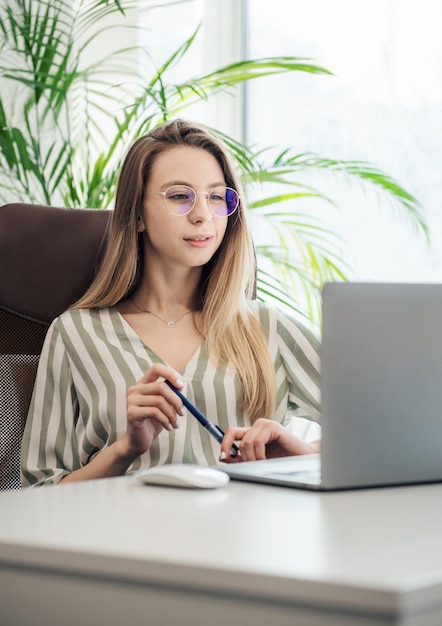 Junge Frau, die an einem Computer arbeitet