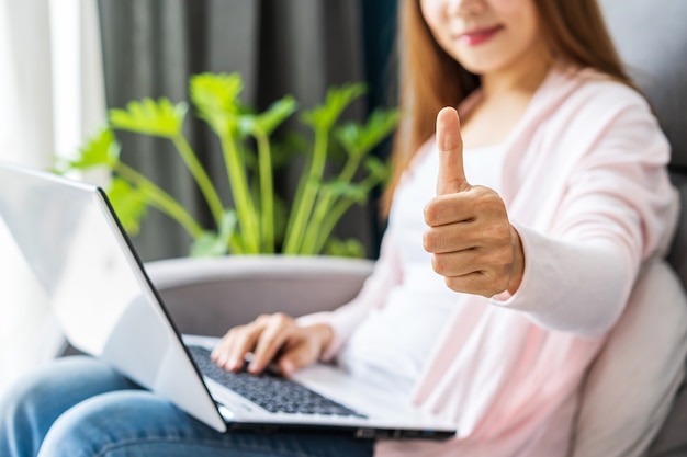 Junge Frau, die an einem Laptop arbeitet