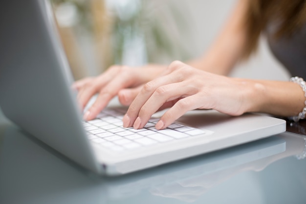 Junge Frau, die an Laptop arbeitet