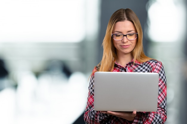 Junge Frau, die an Laptop arbeitet