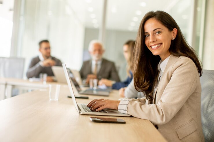 Foto junge frau, die an laptop im büro arbeitet