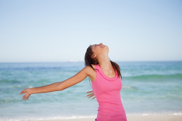 Junge Frau, die auf dem Strand ein Sonnenbad nimmt