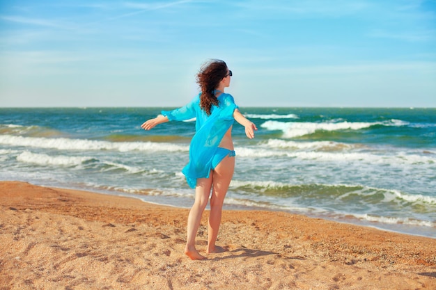 Junge Frau, die auf den Strand geht