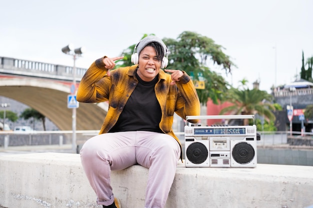 Junge Frau, die auf der Straße neben ihrer alten Ghettoblaster rappt Konzept-Freestyle-Lifestyle-Musik
