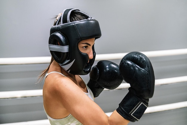 Junge Frau, die auf einem Boxring in Wachposition steht