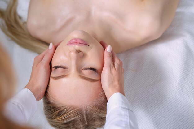 Junge Frau, die auf einem Massagetisch liegt und sich mit geschlossenen Augen entspannt, Frau Spa-Salon
