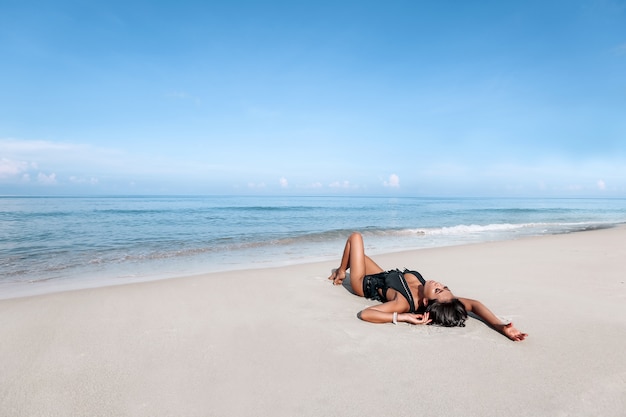 Junge Frau, die auf einem Strand aufwirft