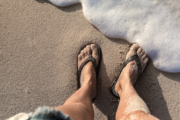 Junge Frau, die auf Sandy Beach steht