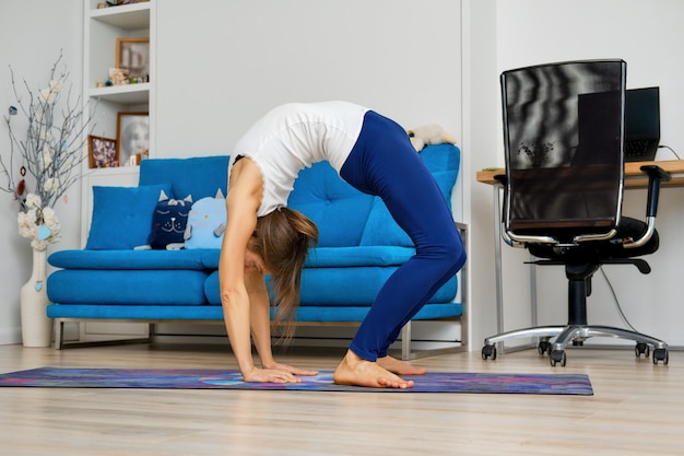 Junge Frau, die Aufwärtsbogenyogapose tut