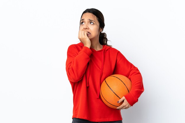 Junge Frau, die Basketball lokalisiert spielt