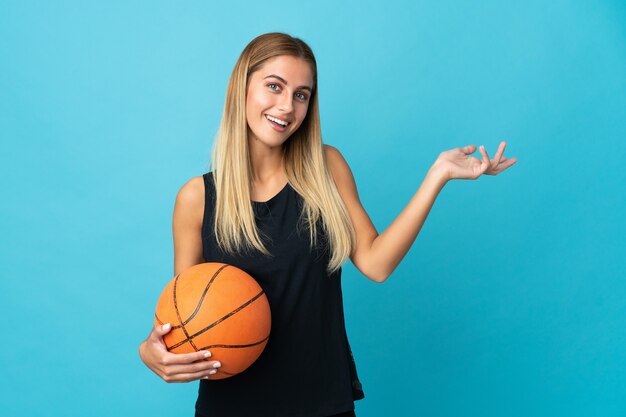 Junge Frau, die Basketball spielt, der lokal gegen die leere Wand aufwirft