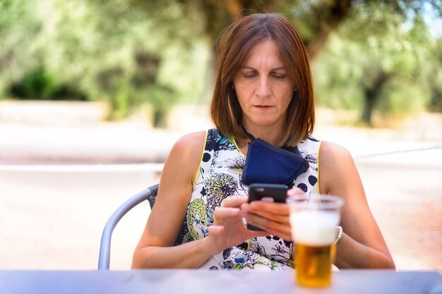 junge Frau, die Bier im Park trinkt