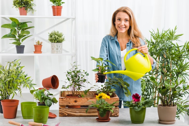 Foto junge frau, die blumen gießt