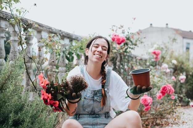 Junge Frau, die Blumen im Garten pflanzt und umpflanzt Konzept der Pflanzenpflege zu Hause Gartenarbeit Junge Frau Floristin kümmert sich um Topfpflanzen