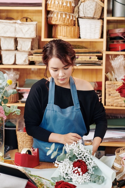 Junge Frau, die Blumenstrauß einwickelt