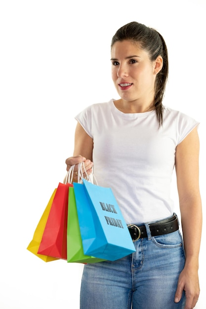Junge Frau, die bunte Taschen auf einem weißen Hintergrund hält Einkaufskonzept Verkäufe Schwarzer Freitag Weihnachten