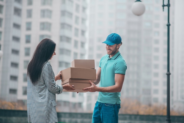 Junge Frau, die den Lieferboten trifft