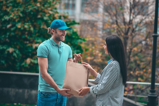 Junge Frau, die den Lieferboten trifft