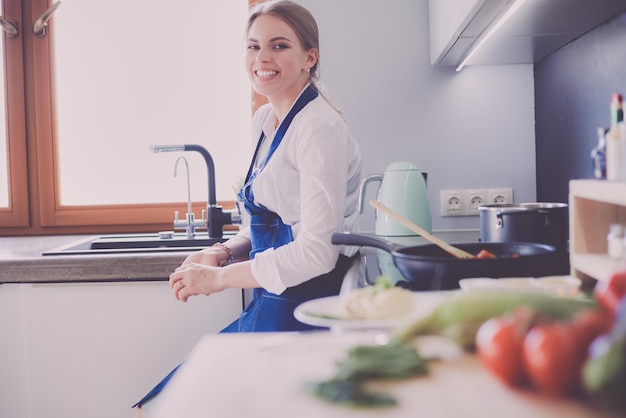 Junge Frau, die den Ofen in der Küche bereitsteht