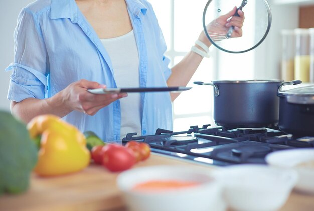 Junge Frau, die den Ofen in der Küche bereitsteht