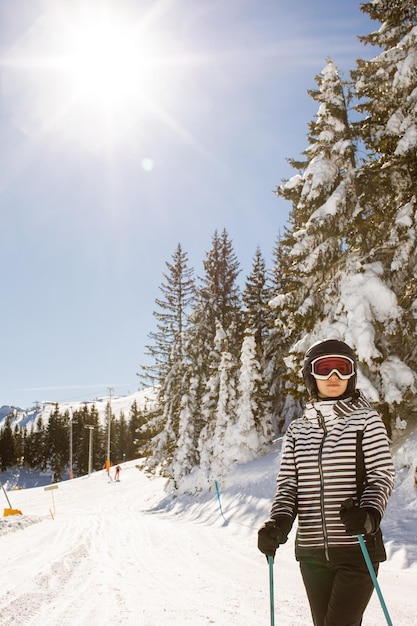 Junge Frau, die den Wintertag des Skispaßes im Schnee genießt