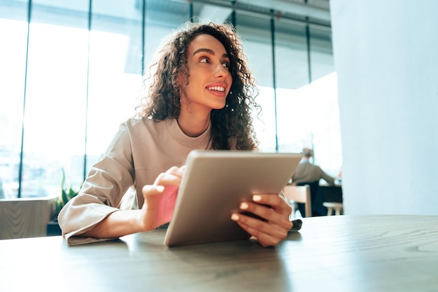 Junge Frau, die Digital-Tablet am Café verwendet