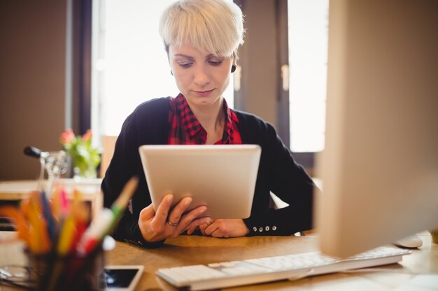 Junge Frau, die digitales Tablett verwendet