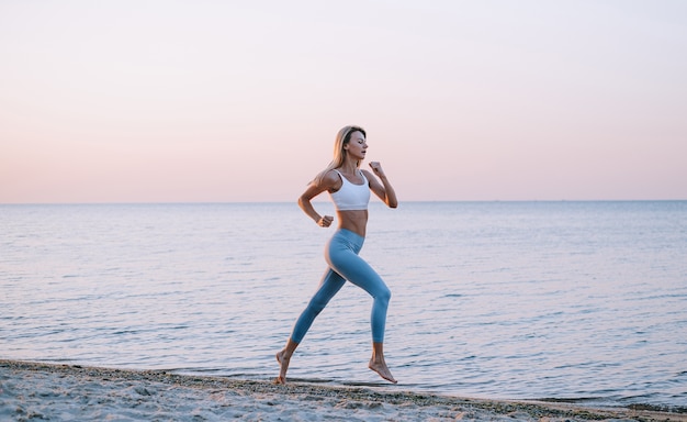 Junge Frau, die durch den Ozean joggt